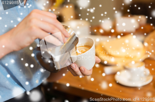 Image of close up of woman making coffee at shop or cafe