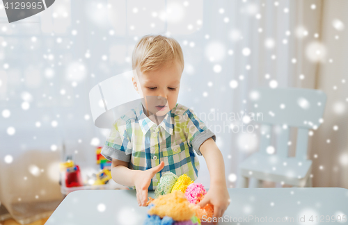 Image of happy little baby boy with ball clay at home