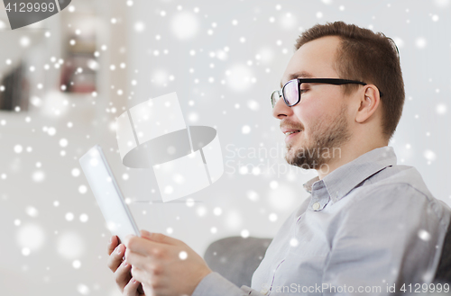 Image of smiling man working with tablet pc at home