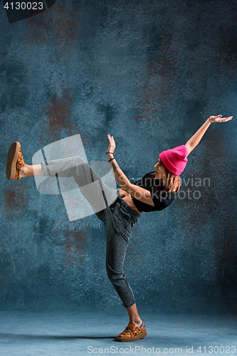 Image of Young girl break dancing on wall background.