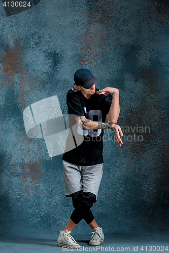 Image of Young man break dancing on wall background.