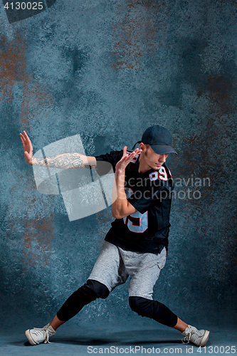 Image of Young man break dancing on wall background.