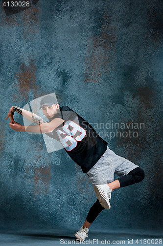 Image of Young man break dancing on wall background.