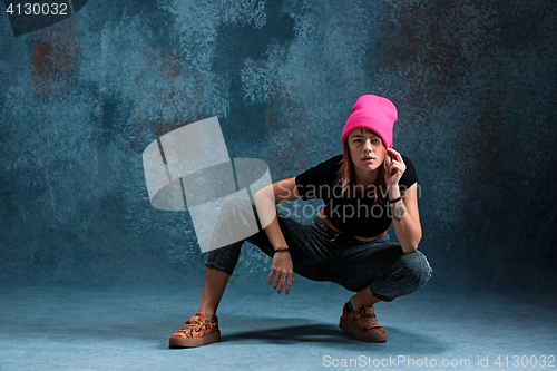 Image of Young girl break dancing on wall background.