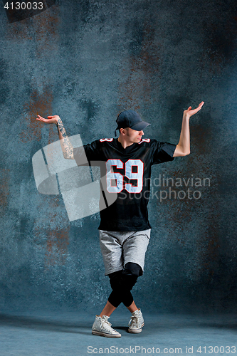 Image of Young man break dancing on wall background.