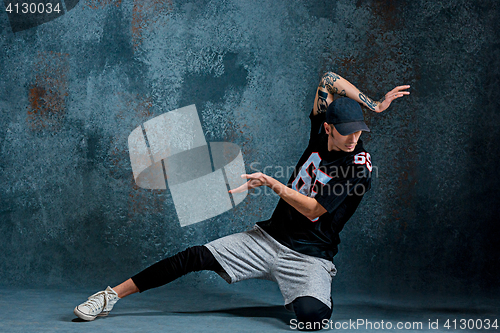 Image of Young man break dancing on wall background.