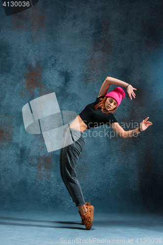 Image of Young girl break dancing on wall background.