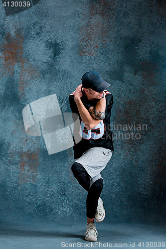 Image of Young man break dancing on wall background.