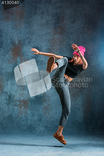 Image of Young girl break dancing on wall background.