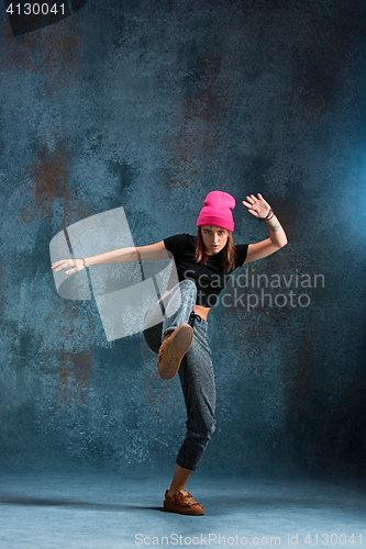 Image of Young girl break dancing on wall background.