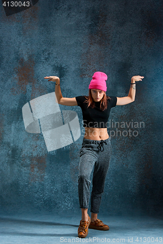 Image of Young girl break dancing on wall background.