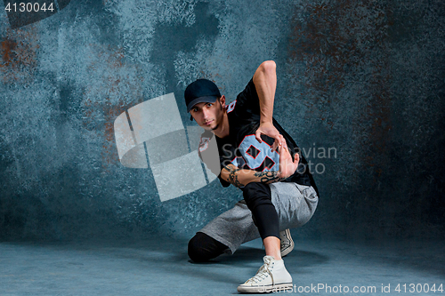 Image of Young man break dancing on wall background.