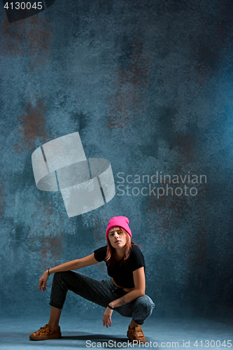 Image of Young girl break dancing on wall background.