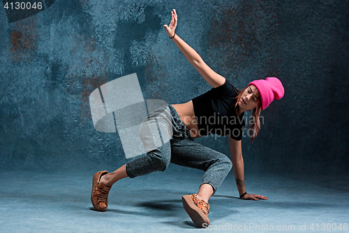 Image of Young girl break dancing on wall background.