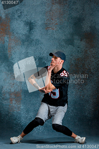 Image of Young man break dancing on wall background.