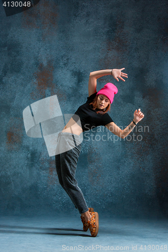 Image of Young girl break dancing on wall background.