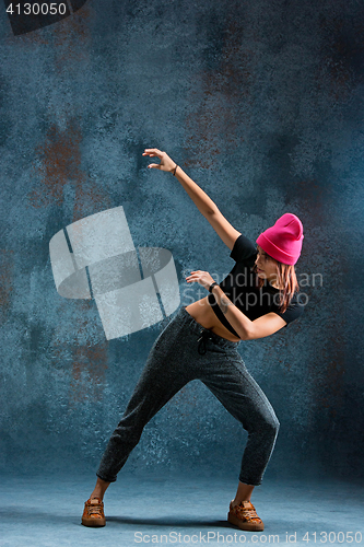 Image of Young girl break dancing on wall background.