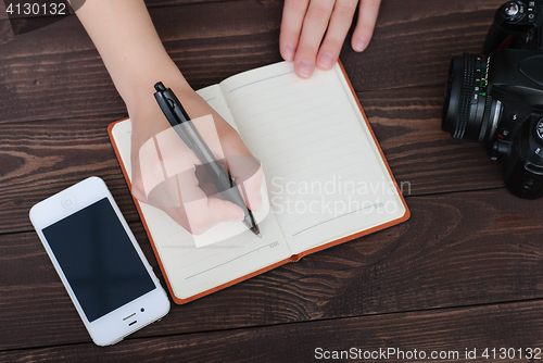 Image of Top view of a hands with pen and notepad