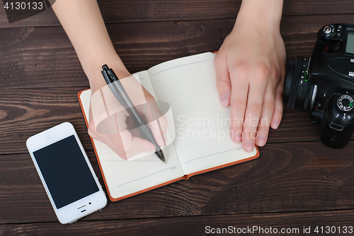 Image of Top view of a hands with pen and notepad