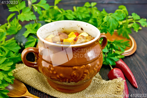 Image of Roast meat and potatoes in pot on dark board