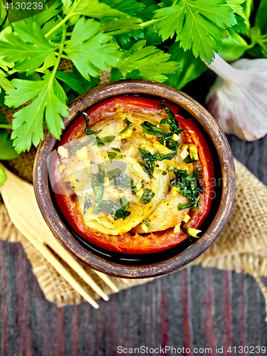 Image of Fish baked with tomato in clay bowl on board top