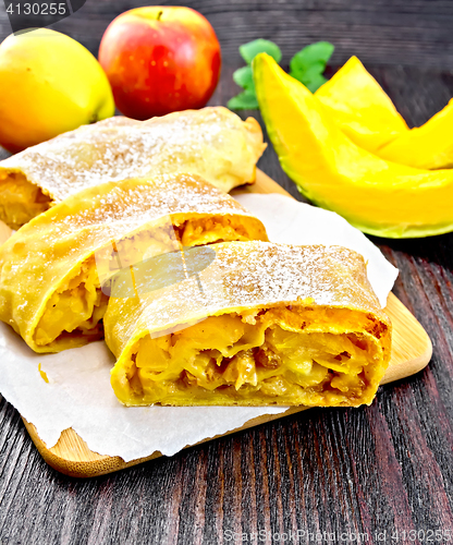 Image of Strudel pumpkin and apple with raisins on wooden board