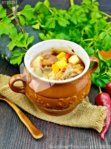 Image of Roast meat and potatoes in pot on sacking