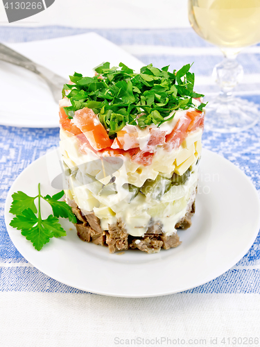 Image of Salad with beef and tomato on blue tablecloth