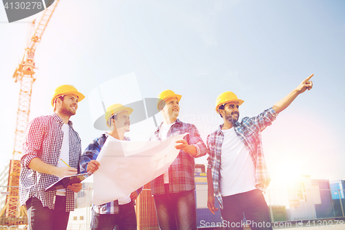 Image of group of builders with tablet pc and blueprint