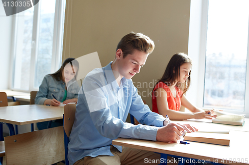 Image of group of students with books writing school test