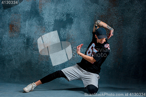 Image of Young man break dancing on wall background.