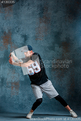 Image of Young man break dancing on wall background.