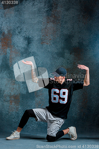 Image of Young man break dancing on wall background.