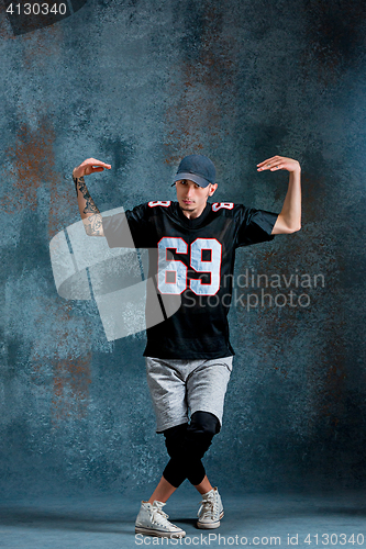 Image of Young man break dancing on wall background.