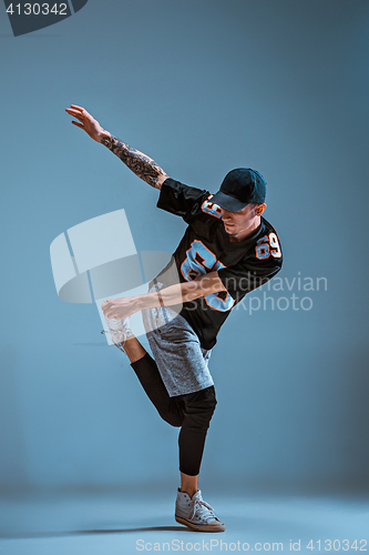 Image of Young man break dancing on wall background.