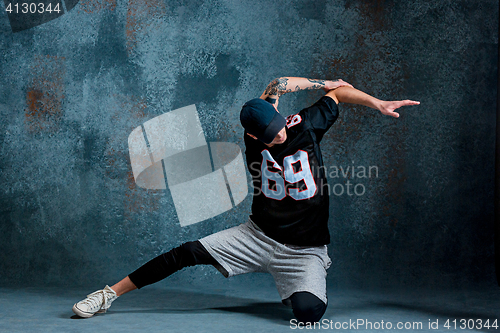 Image of Young man break dancing on wall background.