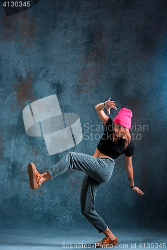 Image of Young girl break dancing on wall background.