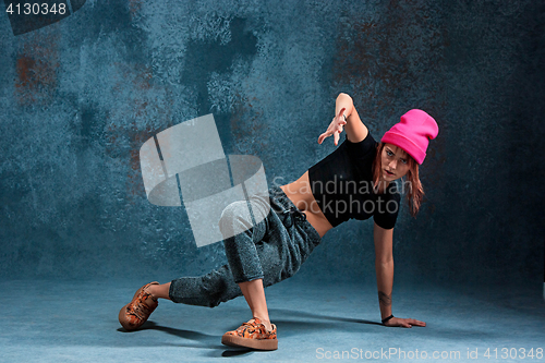 Image of Young girl break dancing on wall background.