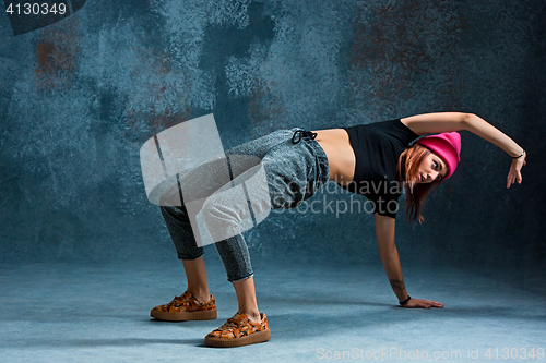 Image of Young girl break dancing on wall background.