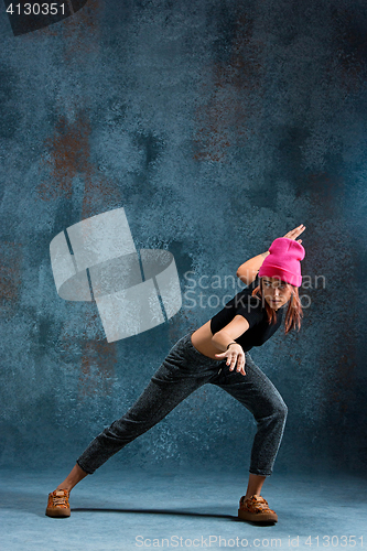 Image of Young girl break dancing on wall background.