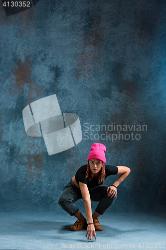 Image of Young girl break dancing on wall background.