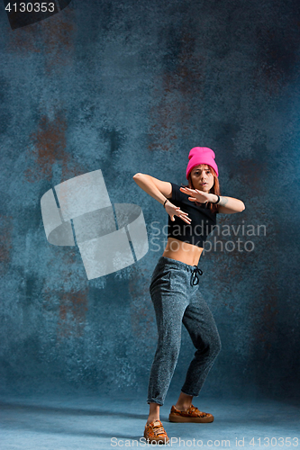 Image of Young girl break dancing on wall background.