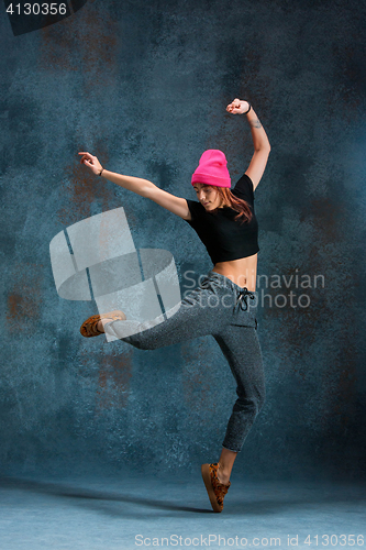 Image of Young girl break dancing on wall background.