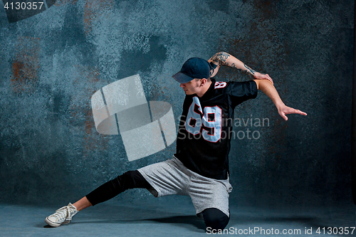 Image of Young man break dancing on wall background.