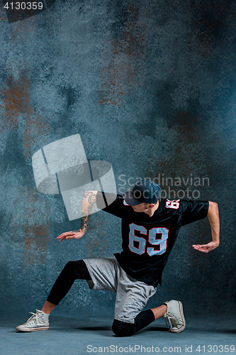 Image of Young man break dancing on wall background.