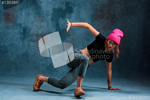 Image of Young girl break dancing on wall background.