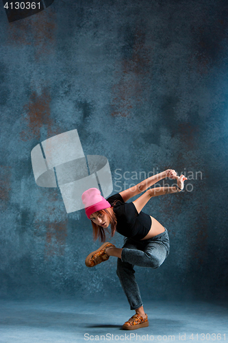 Image of Young girl break dancing on wall background.