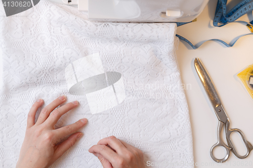 Image of Girl prepares fabric for sewing