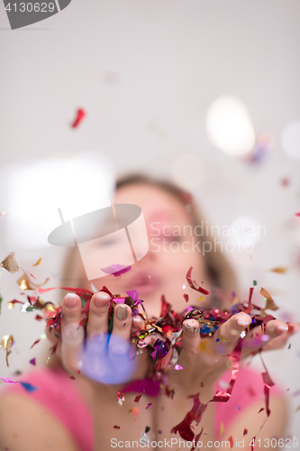 Image of woman blowing confetti in the air