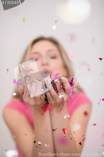 Image of woman blowing confetti in the air